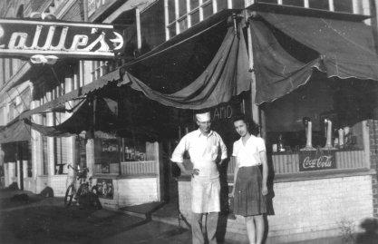 man and woman stand outside Rollie's cafe